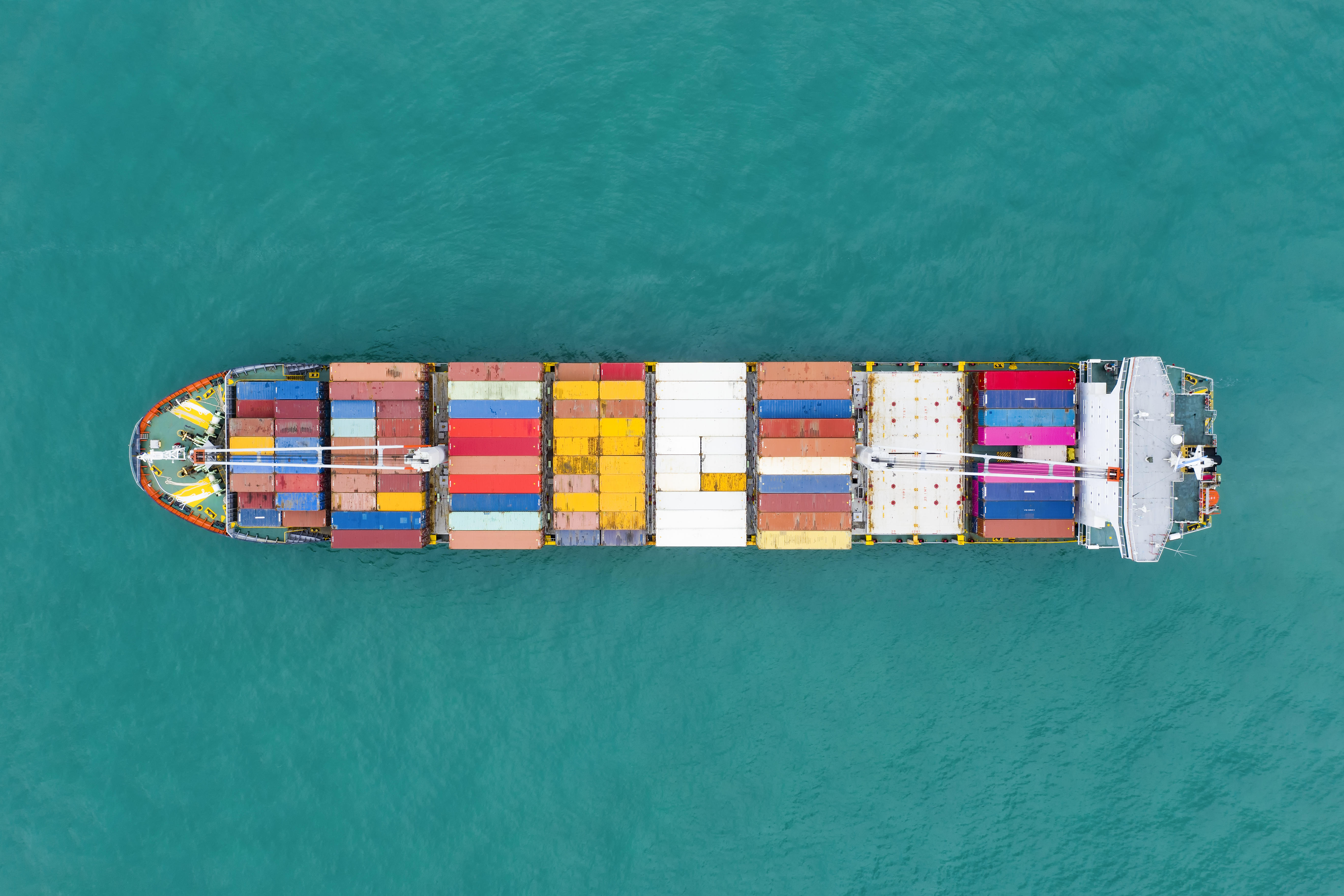 2AAX96P View from above, stunning aerial view of a cargo ship sailing with hundreds of colored containers direct to the port of Singapore.